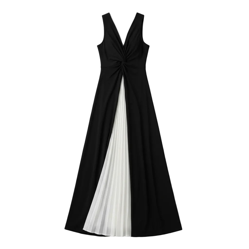 A woman models a sleeveless maxi dress with a black bodice and a pleated split skirt in black and white, standing against a gray tiled wall.