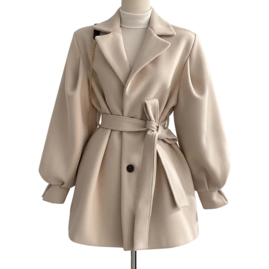 Beige trench coat worn by a person on a plain background