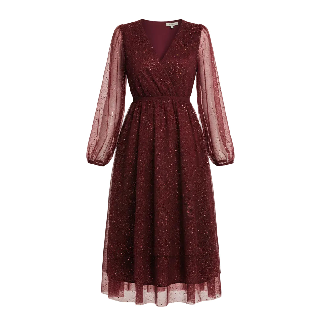 Woman wearing a burgundy sequin dress in a festive indoor setting with Christmas decorations.
