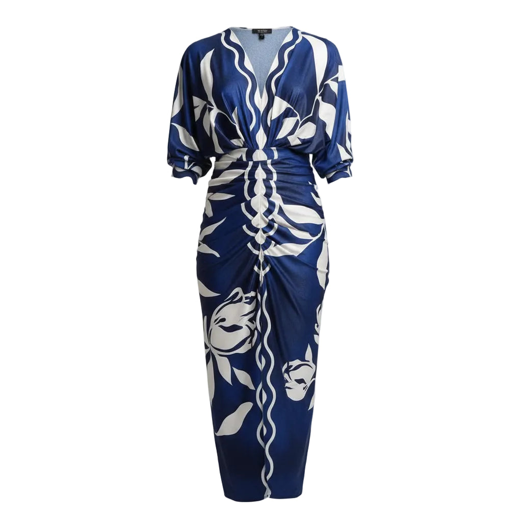 Woman wearing a blue and white patterned dress walking outdoors.