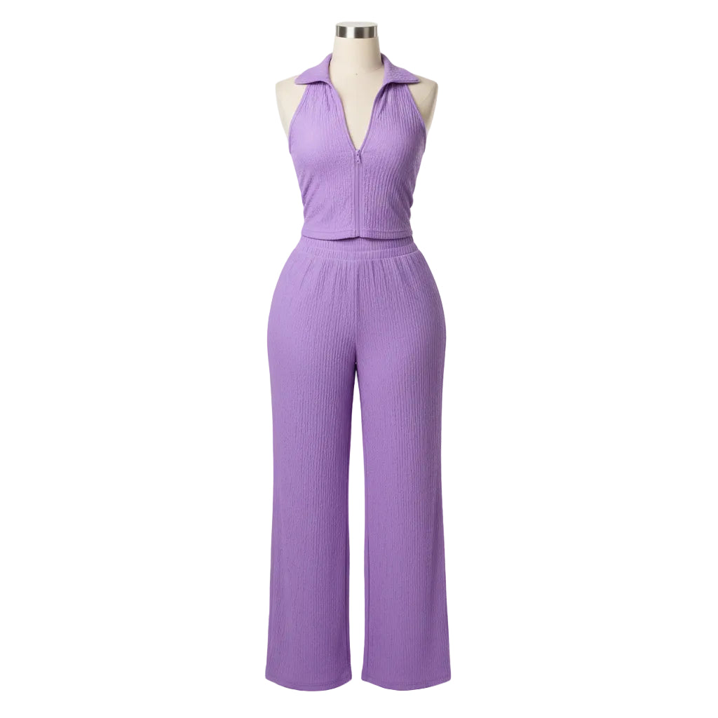 Woman in a purple jumpsuit standing in a doorway.